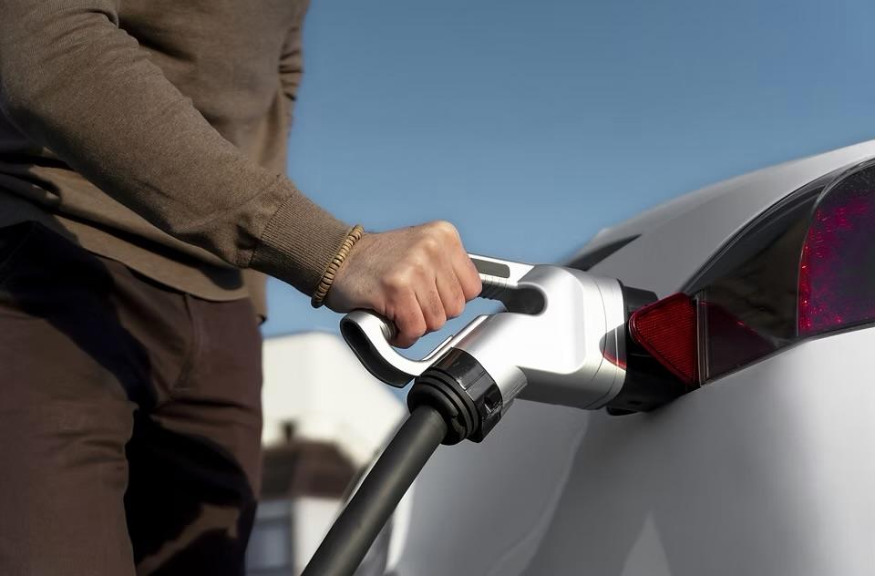 Un conducteur branche son véhicule électrique sur une borne de recharge